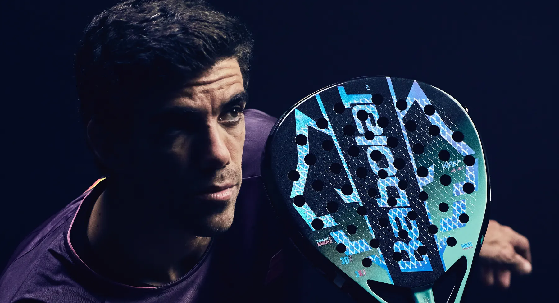 Juan Lebrón sostiene junto a su cara la pala nueva de Babolat por su cara azul y verde menta, con la palabra Viper serigrafiada